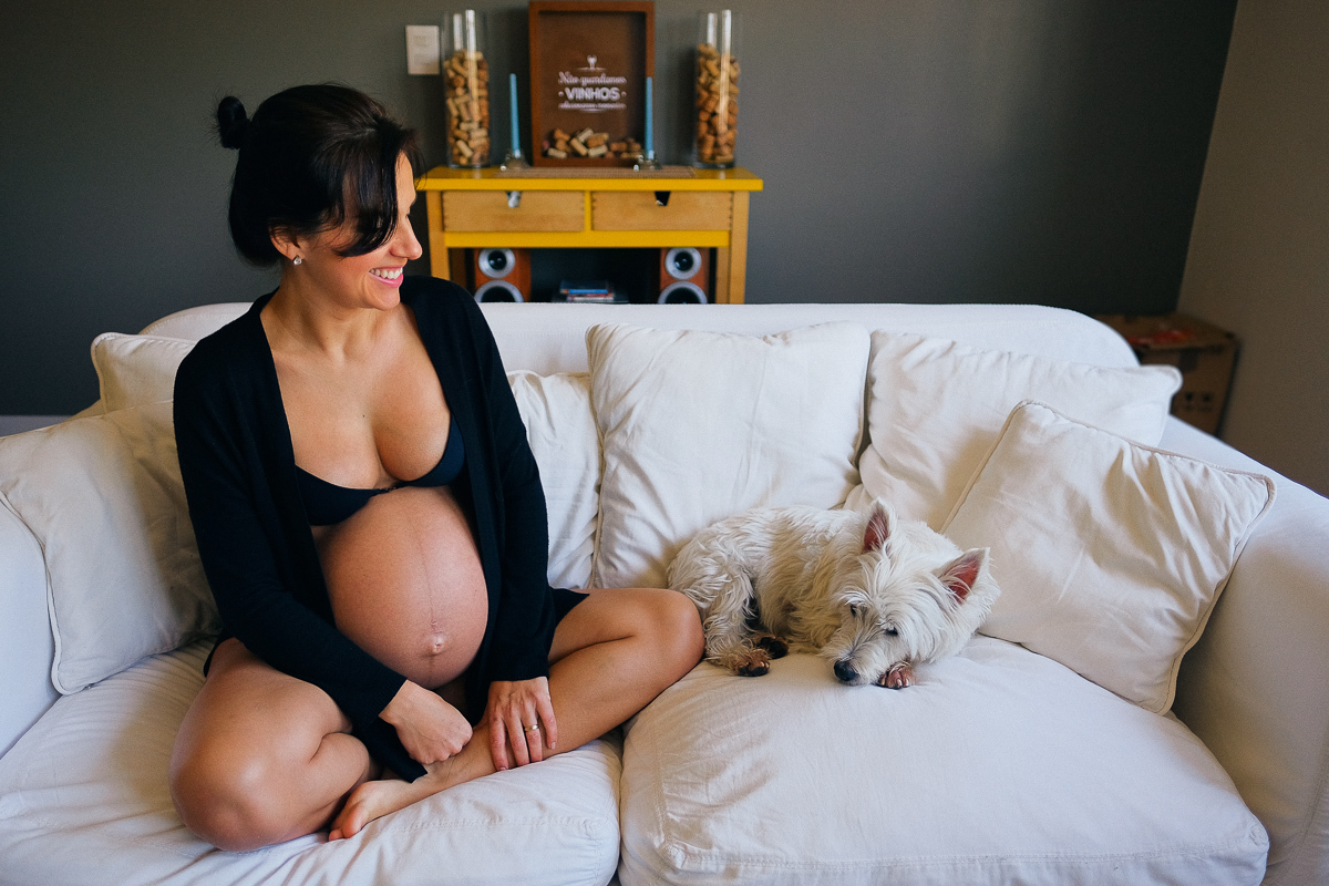 flavia e seu fiel companheiro aipim sentados no sofá da casa dela em registro cheio de carinho feito pela fotografa de familias e gestantes isis vieira em florianopolis sc