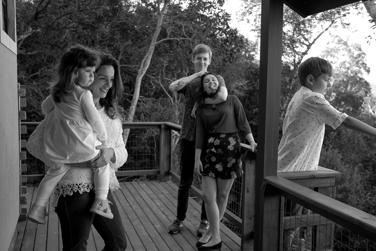 mãe e filhos olhando a linda paisagem da lagoa da conceição  vista da casa da família em ensaio fotografico realizado em florianópolis 