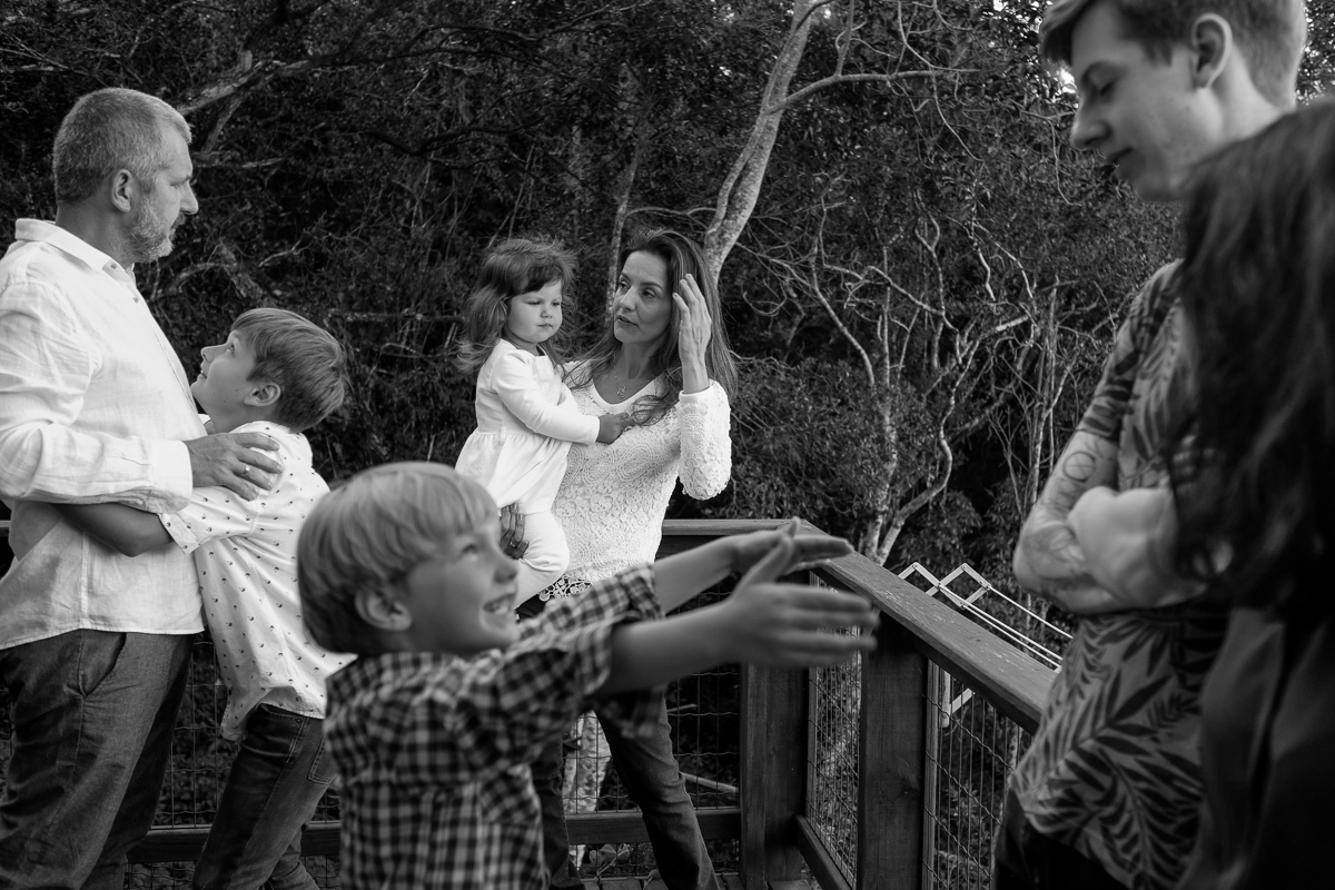 família reunida e interagindo uns com os outros em momento descontraído no ensaio de família realizado na casa da família em florianópolis na lagoa da conceição