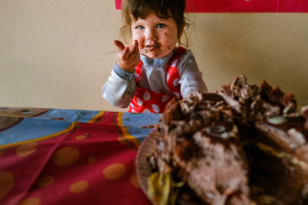registro muito engraçado da sophie com as bochechas todas sujas de bolo de chocolate em sua festa infantil com fotografia de Isis Vieira em florianopolis 