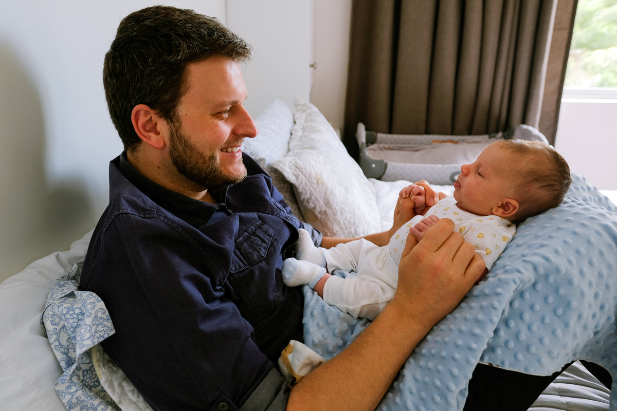 o pai sorrindo olha carinhosamente para o seu filho