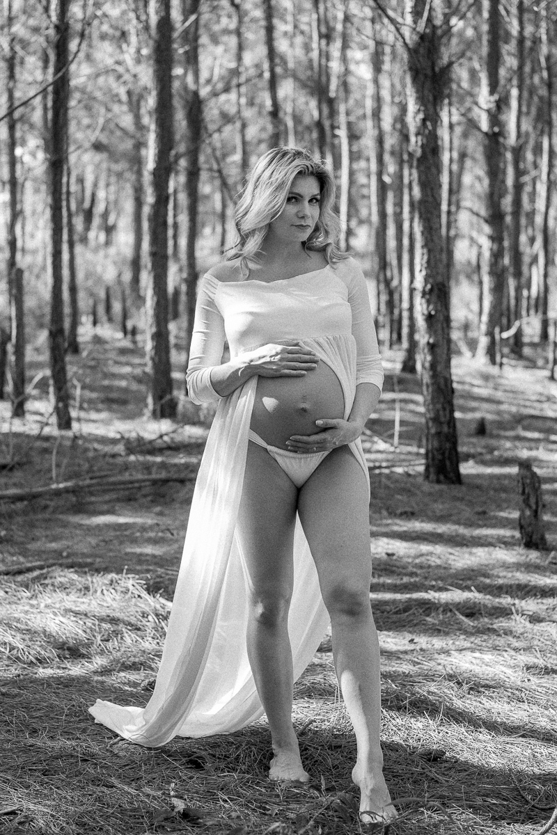 registro em preto e branco da gestante segurando a sua barriga de gravida 