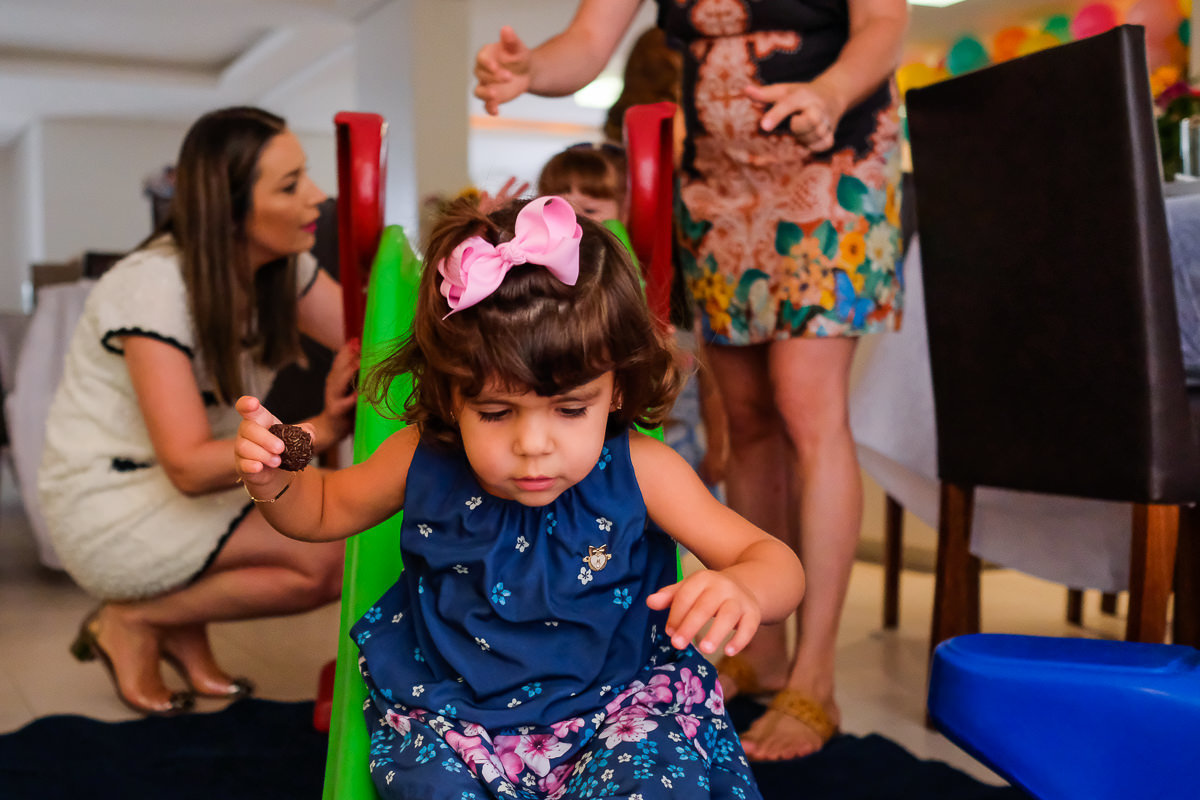 retrato das amiguinhas da Isabela brincando no escorregador durante aniversário infantil em cobertura estilo documental