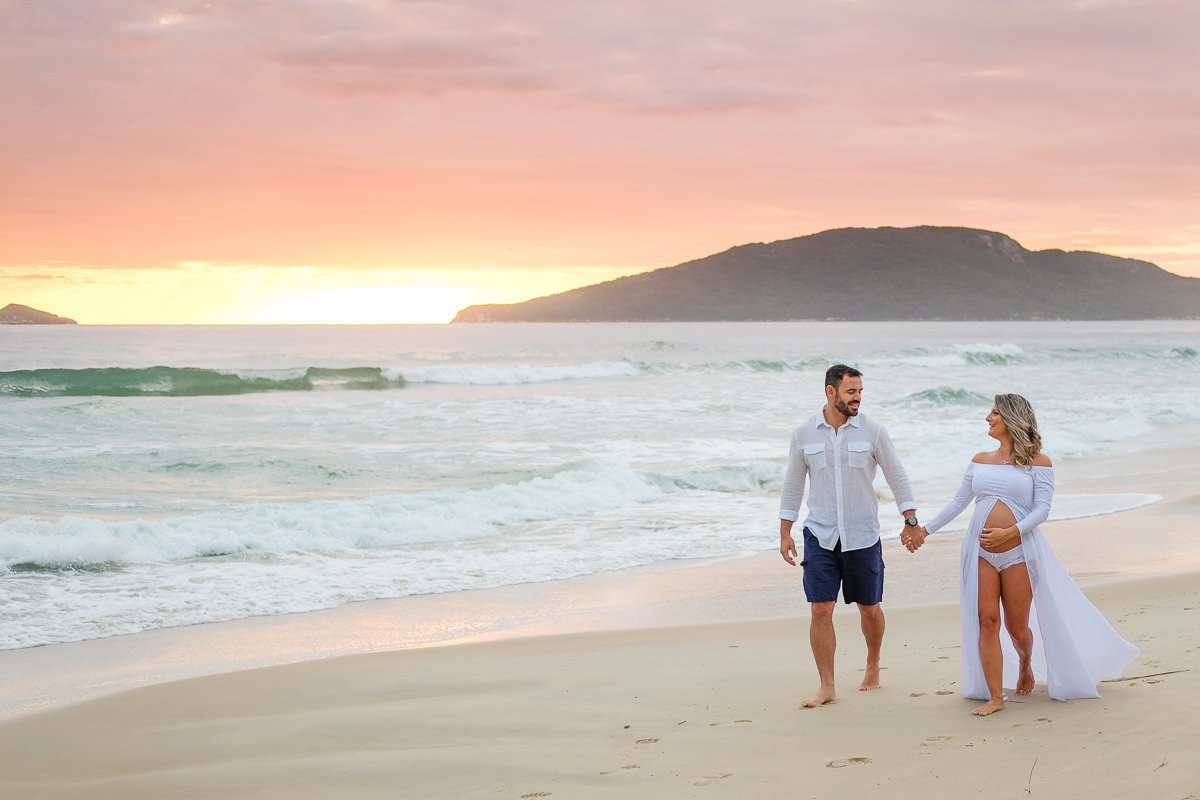 casal caminhando na praia nos primeiros raios de sol no canto das Gaivotas nos Ingleses