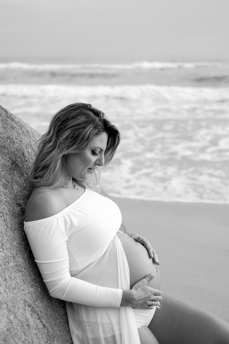 a gravida Alana acariciando sua barriga em ensaio gestante na praia dos Ingleses Florianópolis Santa Catarina