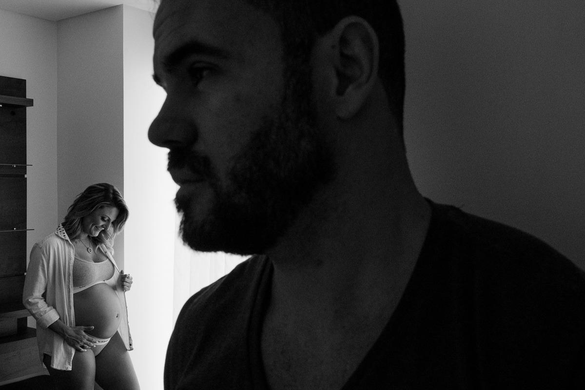 silhueta do papai e sua amada grávida ao fundo na sala de casa