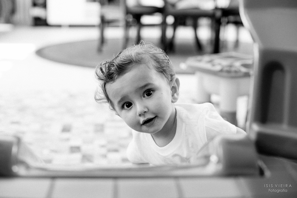 Criança curiosa olhando a fotógrafa registrando sua brincadeira no escorrega bundas na sua festa infantil