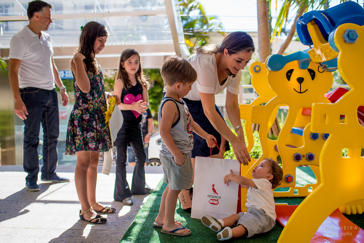 o aniversariante recebendo seu primeiro presente na sua festinha festinha infantil que foi dado por seus convidados