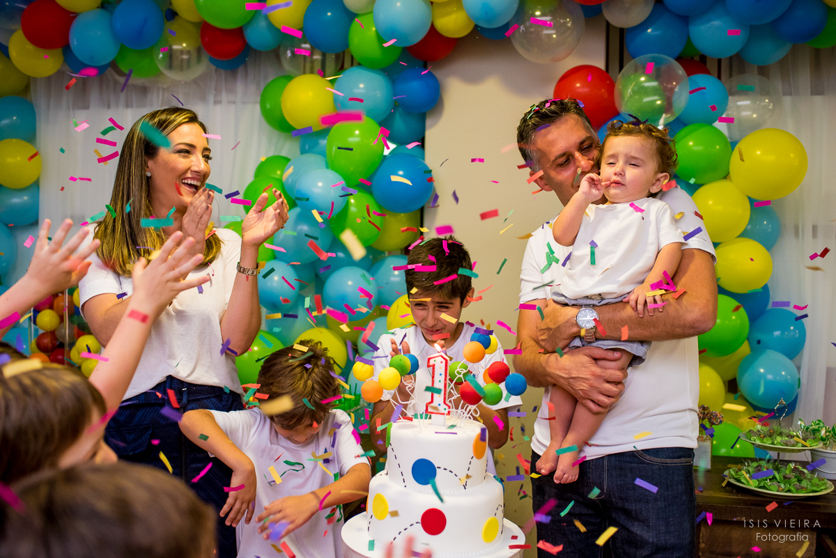 muitos papéis picados coloridos caindo como chuva para comemorar o primeiro aninho do aniversariante