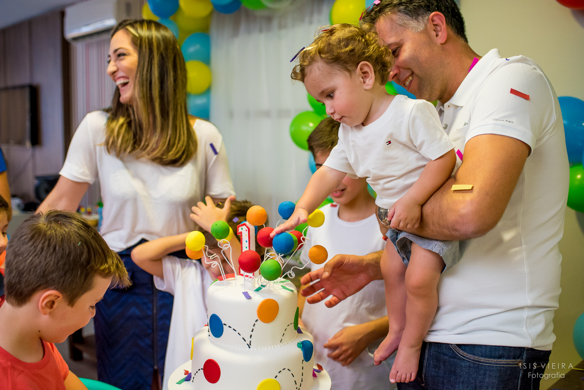 aniversariante brincando com seu lindo bolo infantil cheio de bolinhas de isopor na sua festinha de 1 aninho decorada e produzida por miss festas