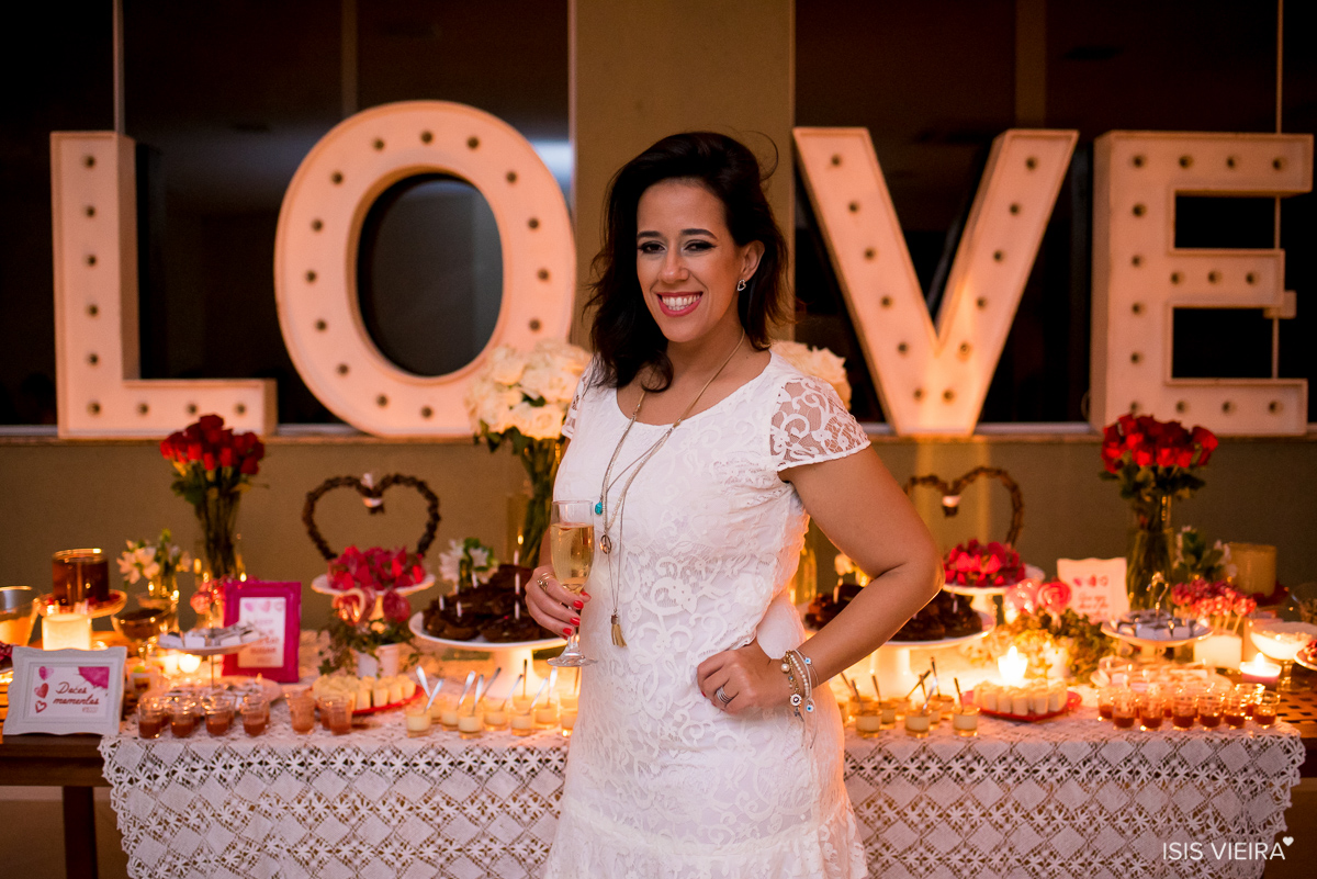 a linda aniversariante roberta almeida posando feliz em registro feito por isis vieira fotografia com a incrível decoração rústica com letras de madeira e velas feita por miss festas em florianopolis