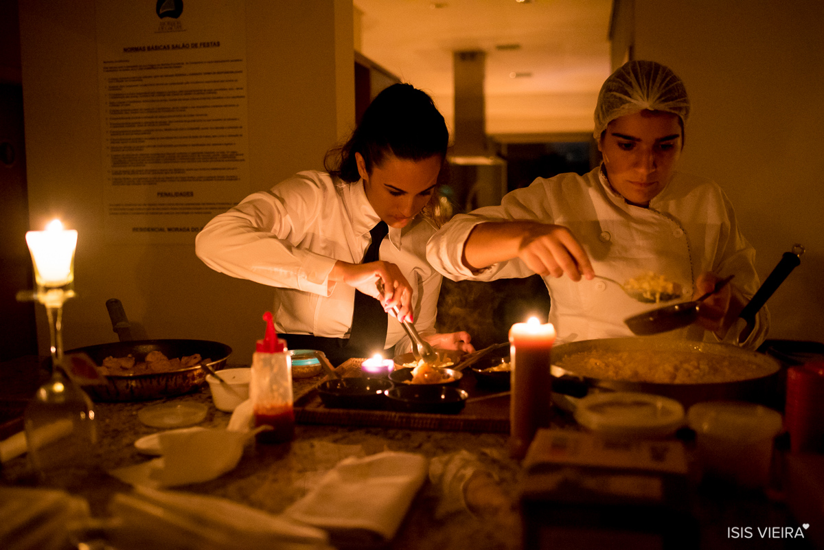 equipe miss festas preparando o jantar do evento social com decoração de velas