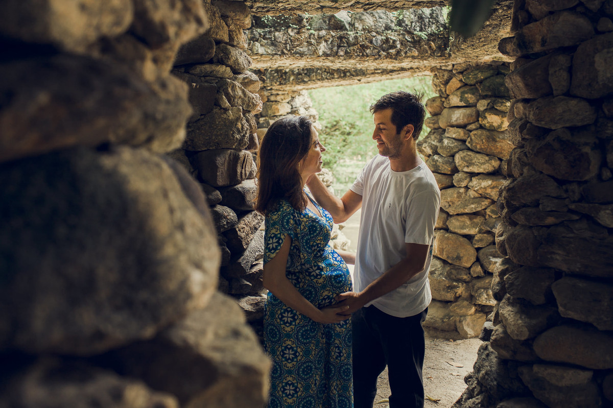 troca de carícias entre casal gestante em casinha de pedras