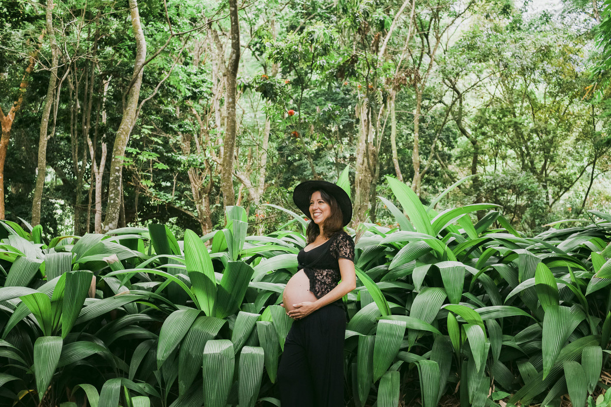gestante romântica posando em floresta com look charmoso preto