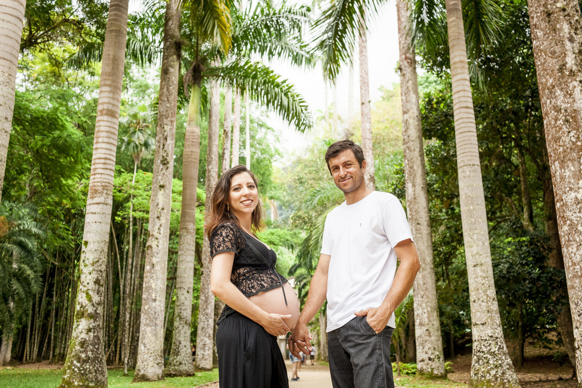 casal gestante posando para o fotógrafo de famílias Paulo h lima em corredor de palmeiras do jardim botânico do rio de janeiro