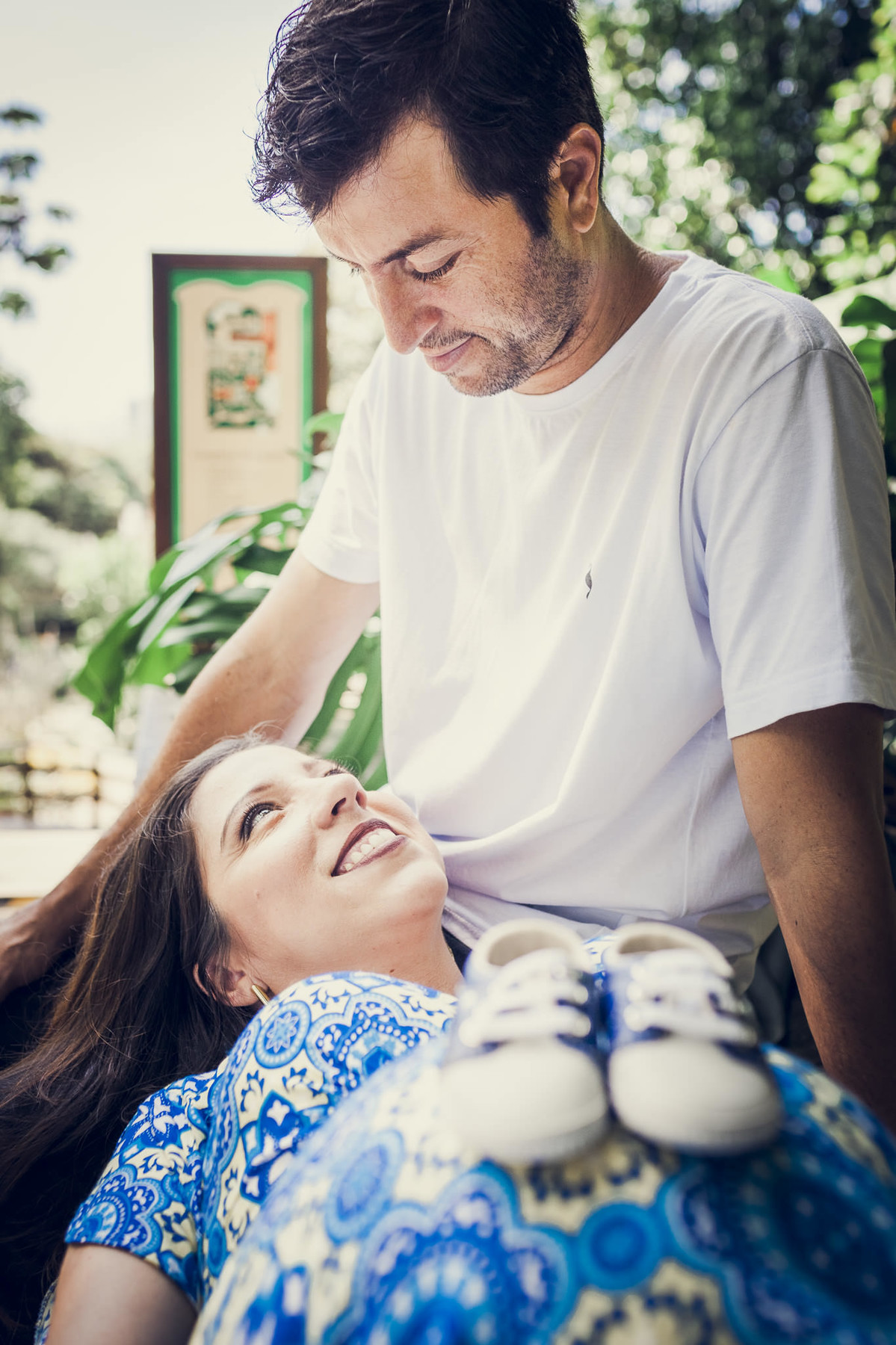 Casal gestante trocando olhares em ensaio romântico