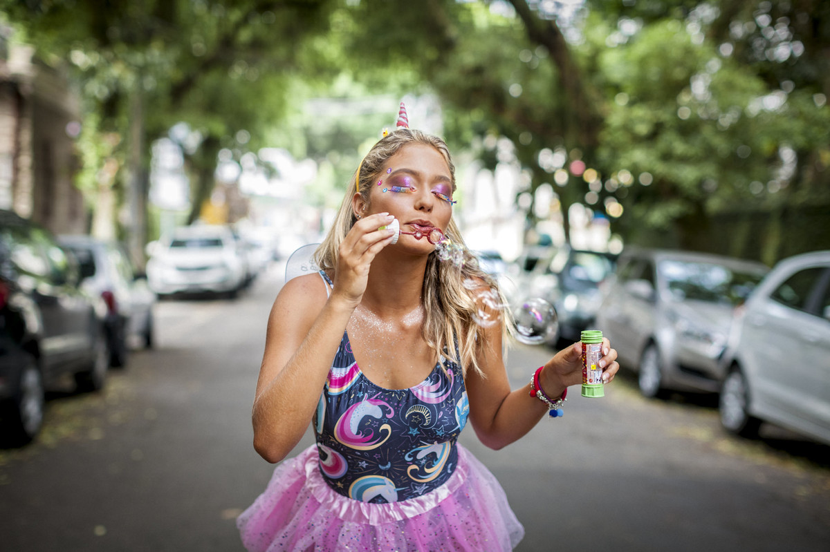 modelo saia rosa translúcida body maiô rosa acessórios carnaval unicórnio bolinhas sabão durante sessão lookbook e-commerce moda praia