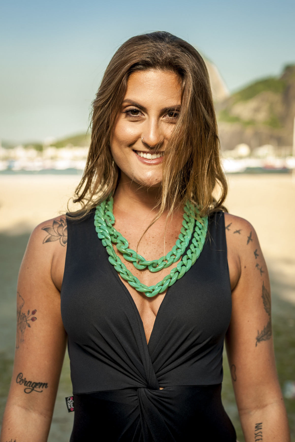 modelo tatuada sorrindo para fotógrafo de moda em ensaio para grife de maios moda praia