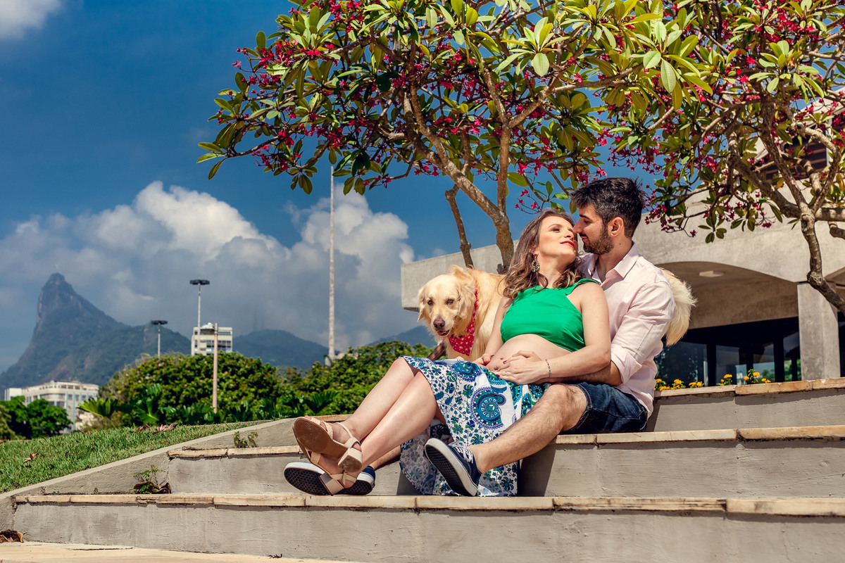casal namorando em escada no aterro do flamengo com cristo redentor ao fundo e labrador observando