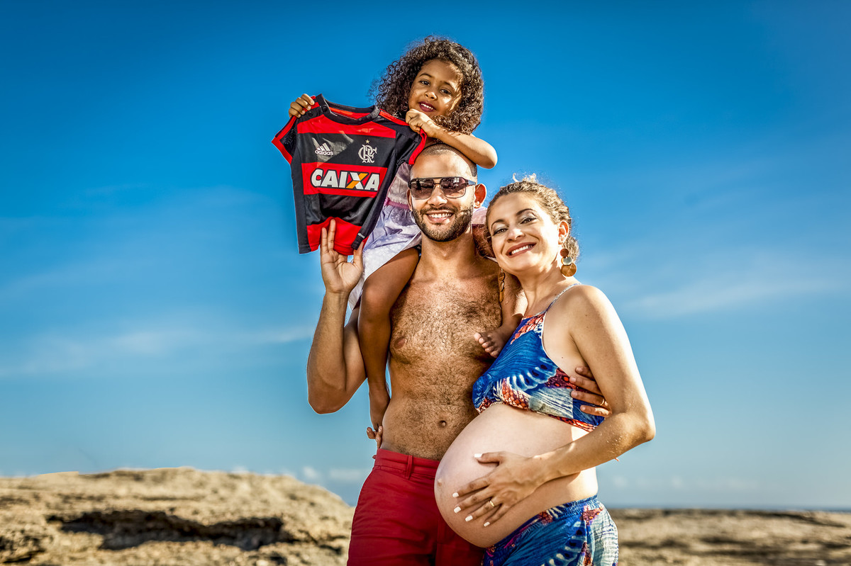 Família flamenquista brincando com camisa do flamengo em gestação do filgo
