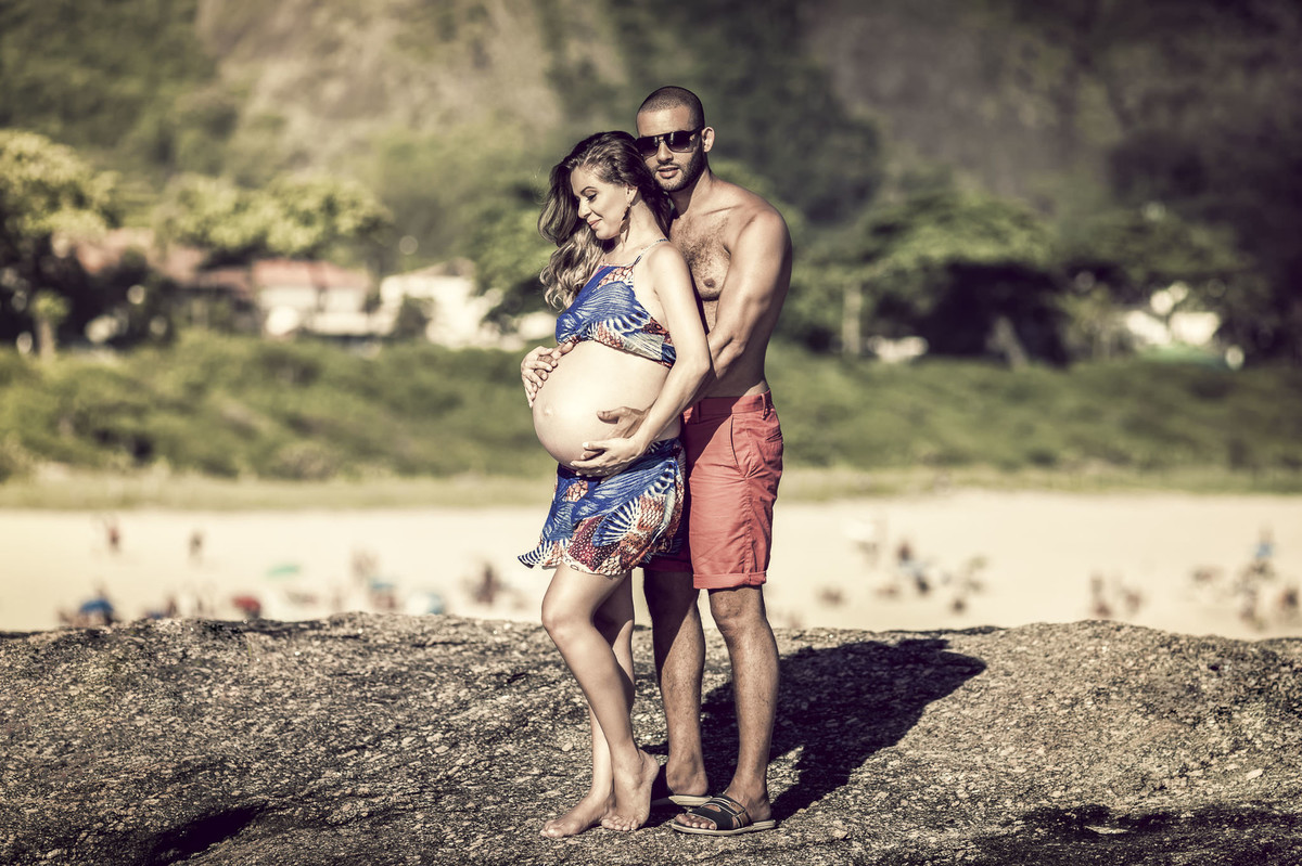 Casal curtindo a gestação em ensaio de gestante feito em pedra de itaquatiara
