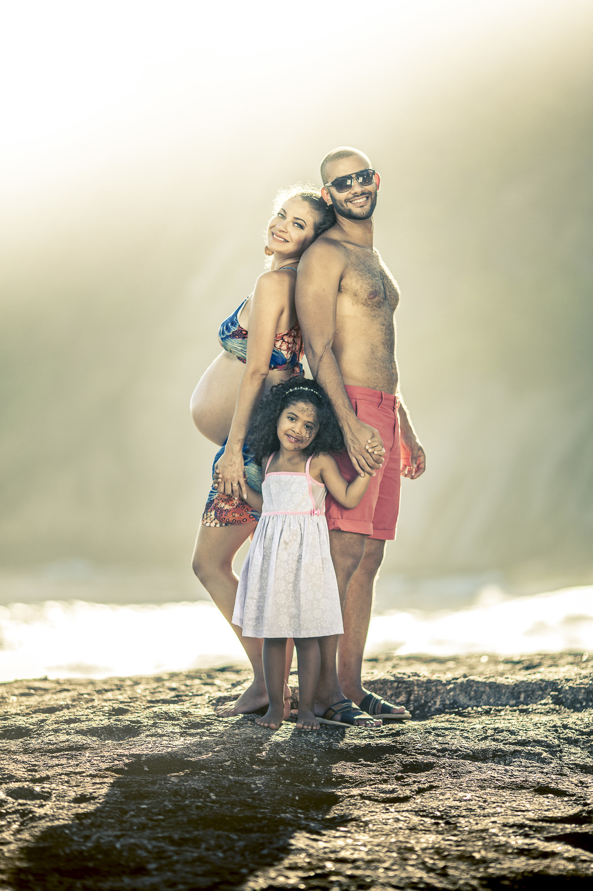 Família sorridente posando para ensaio de gestante em pedra de itaquatiara