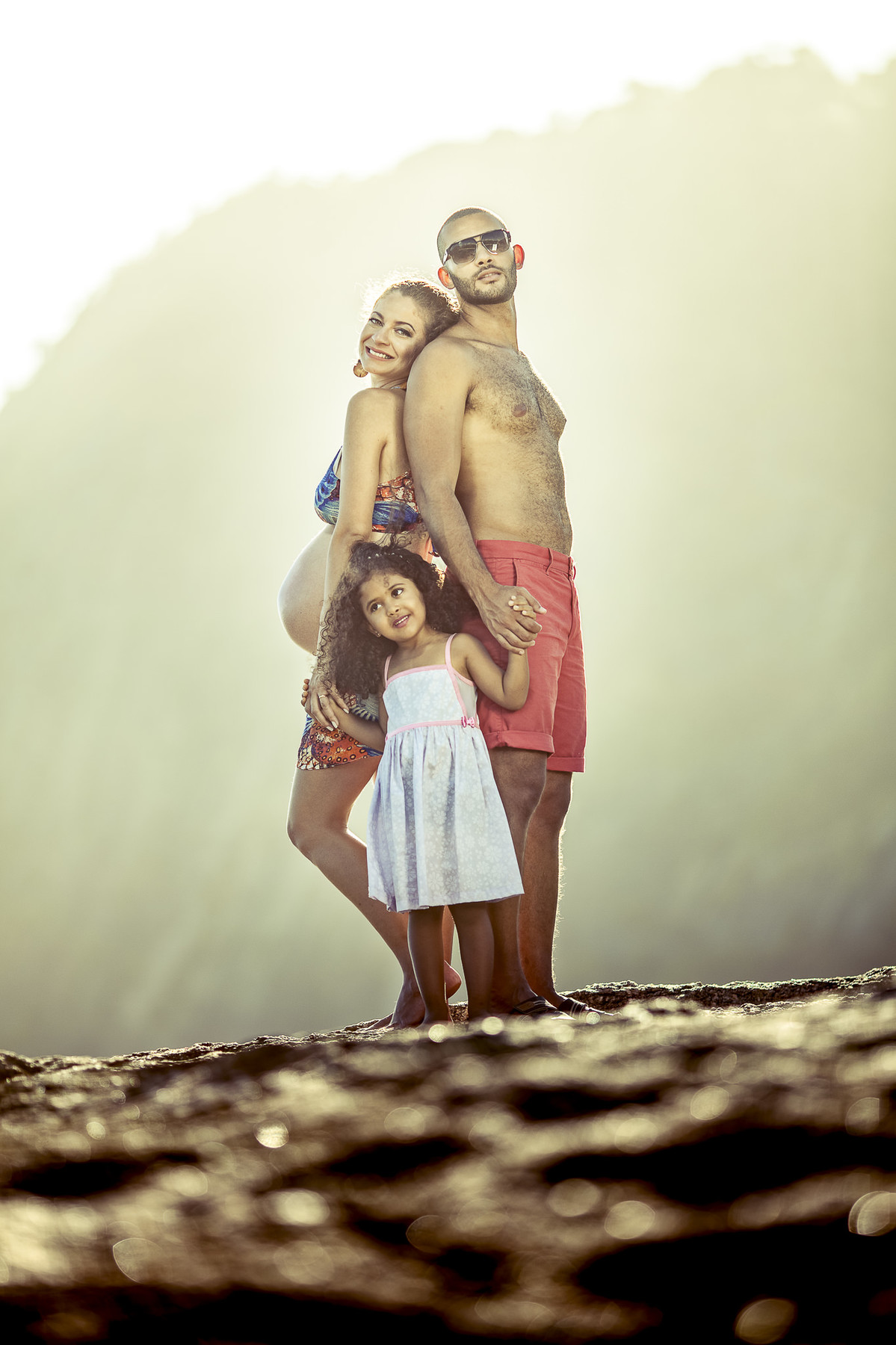 família feliz posando para book de gestante na praia de itaquatiara