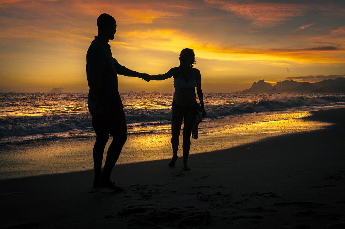 Casal afirmando união em por do sol na praia