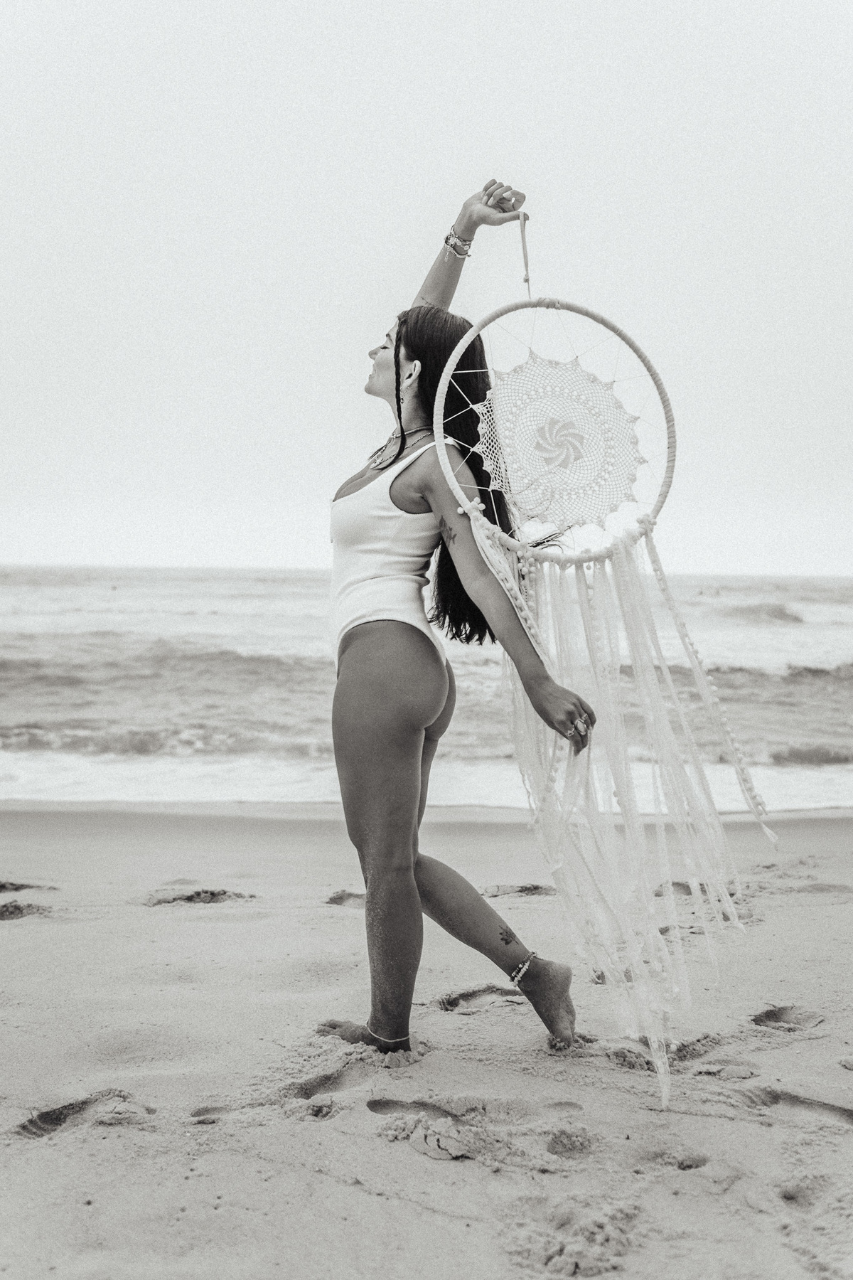 fotografia em preto e branco de modelo na praia com filtro dos sonhos