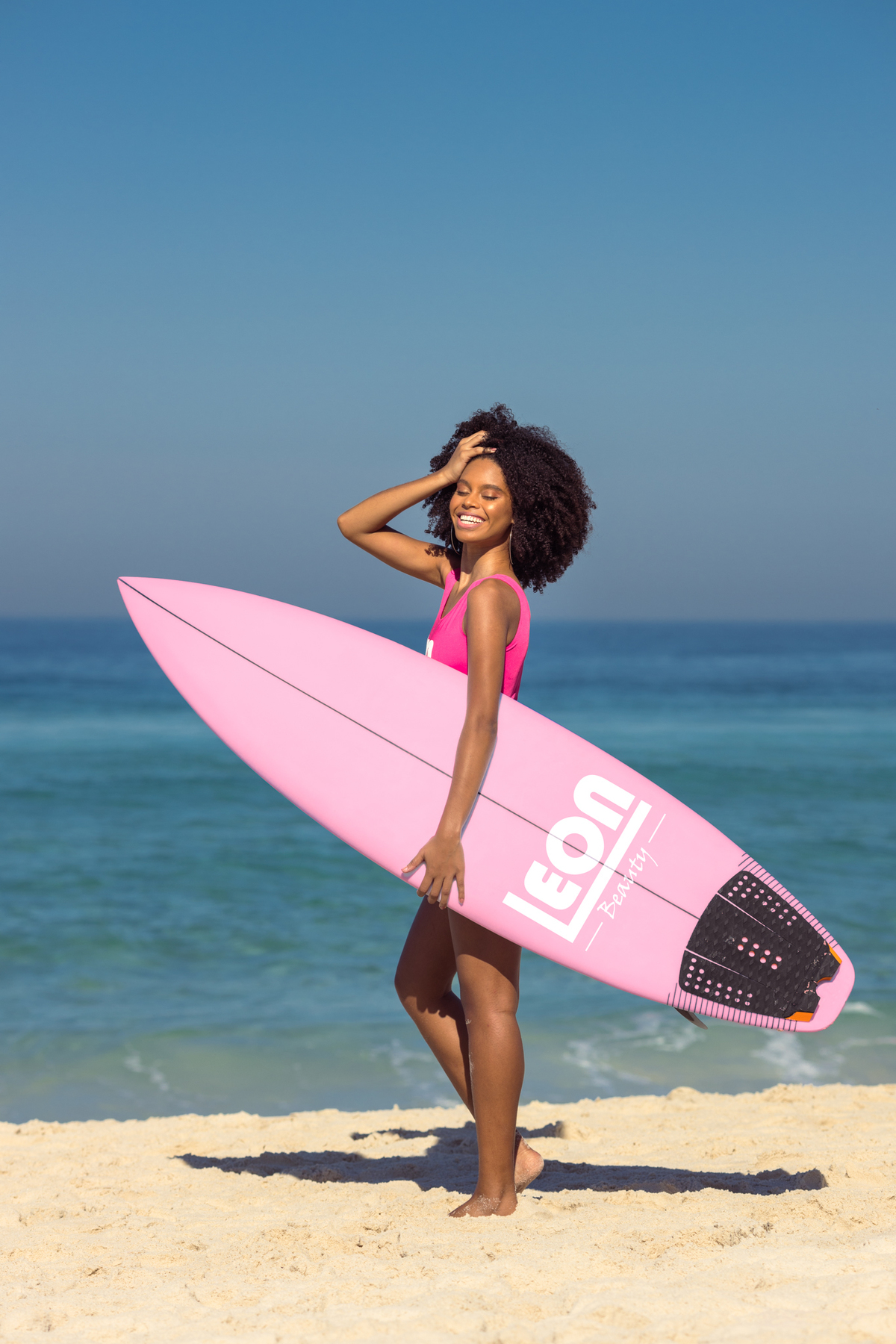 fotografia de moda na praia da barra da tijuca mulher prancha rosa rio de janeiro rj mulher joven negra referência rio de janeiro rj